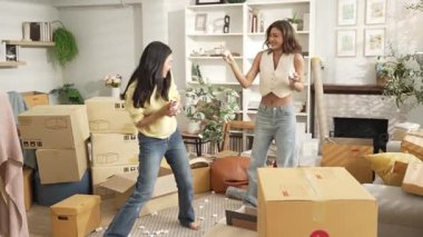 Genç ve güzel lezbiyen çift oturma odasında dans ediyor ve köpük saçıyor. Çekici oda arkadaşı müzik dinlerken yeni bir eve ya da daireye taşınıyor ve karton kutu dağınık. Myrmidon.