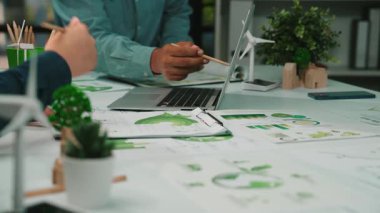 Canlı bir ofis, sürdürülebilir fikirler, çevre dostu projeler ve doğanın iş uygulamalarına entegrasyonu üzerine grafikler ve çizelgeler üzerinde odaklanmış, sergilenen bir takım çalışması hazırlıyor. SACTR