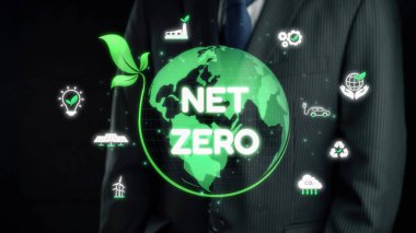 Bir iş adamı net sıfırı temsil eden parlayan yeşil kürenin yanında duruyor ve şirket sorumluluğunda sürdürülebilirliğin ve çevre dostu uygulamaların önemini vurguluyor. Dörtgen