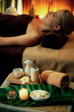 Aromaterapi masajı ambiyansı ya da spa salonu kompozisyon düzeneği bulanık kadınlara odaklı dekor mumları ve spa aksesuarları ile tatil köyü veya otel arka planında keyifli aroma spa masajı yapan. Sessiz.