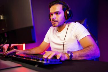 Akıllı oyun kurucusu, dijital neon ışıklandırma stüdyosundaki sosyal medya uygulamasında başkalarıyla iletişim kurmak için kulaklık ve mikrofon kullanan takım üyeleriyle konuşuyor. Tahmin et..