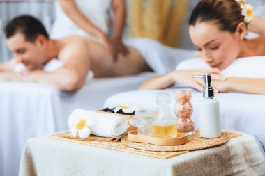 Aromaterapi masajı gündüz atmosferinde ya da spa salonunda bulanık bir kadına odak dekor ve spa aksesuarları kurarak tatil köyünde ya da otel arka planında keyifli aroma spa masajı yapan bir masaj. Sessiz.
