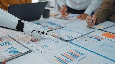 İnsanlar ve robotlar arasında detaylı veri analizleri, çizelgeler ve üretkenlik için yenilikçi takım çalışması stratejilerinin yer aldığı modern bir ofis sahnesi.