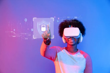 Sanal gerçeklik kulaklığı takan neşeli genç bir birey dijital güvenlik kavramlarıyla etkileşime geçerek, siber güvenlik ve veri korumanın teknolojideki önemini vurguluyor. XDMCP