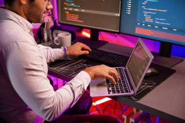 Akıllı IT geliştiricisi, yazılım kodlama sisteminde Neon Light ofis odasında yazı yazmak için çalışıyor, uygulama programı güncellemesi en son online web sitesi veritabanını çevrimiçi yapıyor. Tahmin et..