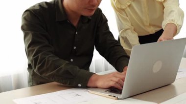 Masada dizüstü bilgisayarda ayrıntılı tasarım görüntüsünü izleyen mimar ve güvenlik mühendisi, diğer bir tasarımcı yazım planı modern ofiste doğruluk için ölçüm aracı kullanıyor. - Yakın çekim. Tanımlama.