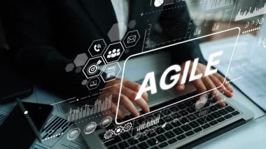 Bir ofis ortamında veri analizi, çizelgeler ve çevik metodoloji grafikleri olan bir dizüstü bilgisayar üzerinde çalışan bir iş adamı. Asemptotik akıllı veri analitiği.