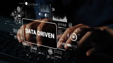 Analitik ve Teknolojiyi temsil eden Veri Sürükleyici Grafikler ve Dijital Elementlerle Karanlık Bir Çevrede Eller Klavyede Yazıyor. Asemptotik akıllı veri analitiği.