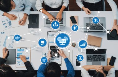 Takım çalışması, dizüstü bilgisayarlar, dijital araçlar ve veri sunumlarının yer aldığı, işbirliği ve üretkenlik stratejilerinin ön plana çıkarıldığı modern bir ofiste iş toplantısı. Dostluk