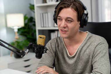 Sunucu kanalı, gülümseyen akıllı yayıncı kaydı, senaryosu ve akıllı telefonuyla sosyal medyada sohbet programı, kulaklık takarak modern ev stüdyosundaki video flamalarını kaydediyor. Bireysel.