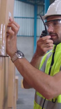 Profesyonel kargo işçisi başka bir işçiyle bağlantı kurmak için telsizle konuşuyor. Fabrika ve depo iletişim konsepti .