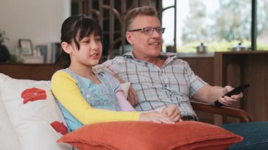 Büyükbaba ve torun birlikte TV 'de ilginç bir eğlence medyası izliyorlar. Eski üst düzey kullanım teknolojisi, genç nesil çapraz nesil ile iletişim kurarak aile bağlarını güçlendiriyor. Uyumsuzluk.