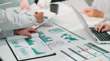 Çeşitli bir ekip, modern bir ofiste işbirlikçi bir yaklaşım sergileyen grafikler, grafikler ve dizüstü bilgisayarlarla çevrili bir toplantı sırasında veri analizine girişiyor. SACTR