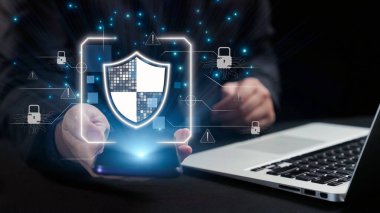 Siber koruma ve güvenliğin önemini vurgulayan, dizüstü bilgisayarı olan birinin elinde tuttuğu bir kalkan simgesinin yer aldığı modern bir dijital güvenlik kavramı. Dörtgen