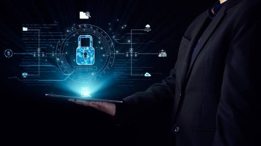 Bir iş adamı, modern güvenlik teknolojisini vurgulayarak, bir kilit sembolü ve veri bağlantılarının yer aldığı dijital güvenliğin görsel temsilini gösteren bir tablet tutuyor. Dörtgen