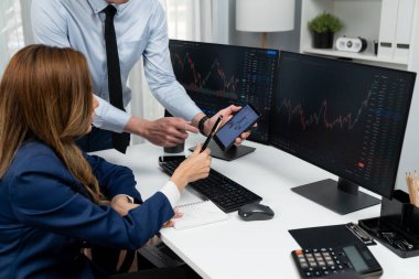 Kâr değeri değeri oranı online web sitesi uygulamasını ev ofisinde analiz etmek için notlar yazan kadınlara telefonda dinamik borsa verilerini gösteren bir işadamı eli kesilmiş. İnfobahn.