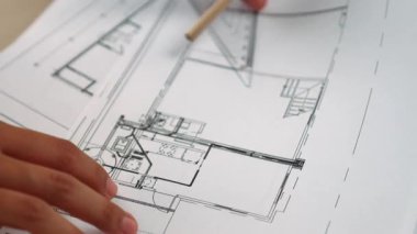 Ölçüm ve yazma aracını kullanarak mimari ofisindeki inşaat doğruluğu için ayrıntılı bir plan tasarlayan akıllı mimar ya da akıllı mühendisin videosu. Eline odaklan. - Yakın çekim. Tanımlama.