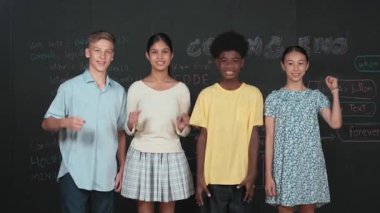 Çeşitli akademik öğrenciler alkışlıyor ve başarılı projeyi el kaldırarak kutluyorlar. Bir grup çok kültürlü çocuk kameraya bakarken elinde mühendislik koduyla tahtada dikiliyorlar. Öğretim