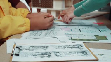 Yaratıcılığı ve takım çalışmasını teşvik etmek için planlar ve modeller üzerinde yoğunlaşan, işbirlikçi bir tasarım atölyesine katılan genç mimarları çeken canlı bir sahne. SACTR