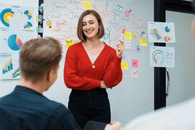 Profesyonel çekici kadın lider, modern iş toplantı odasında beyin fırtınası zihin haritalama istatistikleri ve renkli yapışkan notlar kullanarak yaratıcı pazarlama planını sunuyor. Tertemiz..