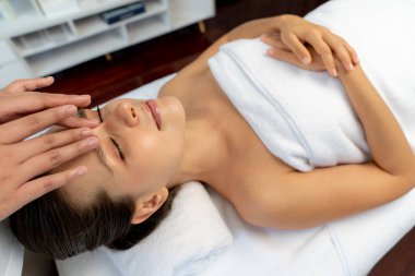 Kafkasyalı kadın stres önleyici kafa masajından ve lüks tatil beldesi ya da otel spa salonundaki modern ışık ortamında yüz güzelliği eğlencelerini şımartmaktan hoşlanıyor. Sessiz.