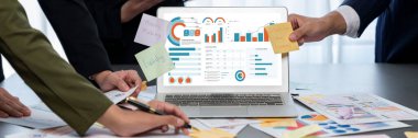 Analizci ekibi yaratıcı ve analitik beyin fırtınası fikri için bilgisayar ekranında BI veri paneli olan yapışkan bir not kullanıyor. Pazarlama stratejisi için finansal veri görselleştirme teknolojisini analiz et. Dahi.