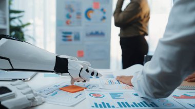 Modern ofis ortamında veri analizi ve yenilikçi teknolojiye odaklanan bir iş görüşmesi sırasında bir insan ve robot arasındaki işbirliğini gösteren dinamik bir sahne.