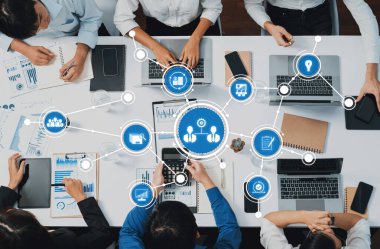 Dinamik bir ekip, veri analizi için dizüstü bilgisayarlar ve dijital araçlar kullanan modern bir çalışma alanında işbirliği yapıyor. Sahne, iş ortamlarında takım çalışması ve yenilikleri gösteriyor. Dostluk