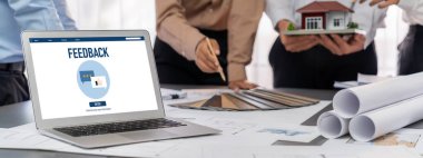 İç mimar tasarımcı grubu, daha kesin tasarım için planlar ve dizüstü bilgisayar ekran mimari yazılımı üzerinde birlikte tartışıyorlar. Modern ev tasarımı ve yenileme. İçgörü