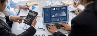 İş zekası ve veri analizi kavramı. Analizci ekibi laptop ekranında finansal veri analizi üzerinde çalışıyor. Etkili iş stratejik planlama için pazarlama göstergesi olarak. İçgörü