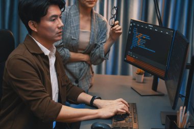 Bilgi teknolojisi geliştiricileri modern ofisteki neon ışık odasında verileri çevrimiçi olarak çalıştıran akıllı web sitesi geliştirme kodlayıcı sistemine işaret ediyorlar. İnfobahn.