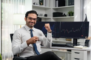 Tüccar işadamının başarısının profili iki borsa yatırım ekranı ile kameraya bakıyor ve dinamik finans teknolojisi grafiği borsasında hızla yükseliyor. Tahmin et..