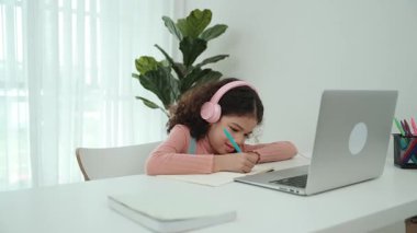 Kulaklık takıp ödevlerini yapan sevimli bir Amerikalı kız. Programlama sistemini araştırırken ve mühendislik komut yazarken defterde yazan mutlu çekici kız öğrenci. Pedagoji.