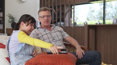 Büyükbaba ve torun birlikte TV 'de ilginç bir eğlence medyası izliyorlar. Eski üst düzey kullanım teknolojisi, genç nesil çapraz nesil ile iletişim kurarak aile bağlarını güçlendiriyor. Uyumsuzluk.