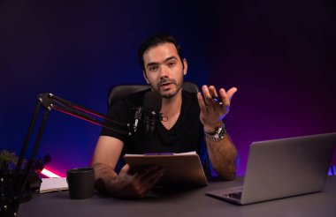 Yayın kuruluşu, mor neon ışık stüdyosunda yaratıcı olumlu düşünce konseptiyle canlı yayında psikoloji, beden ve ruh üzerine eğitim vermek için dinleyiciye senaryo notuyla konuşuyor. Tahmin et..