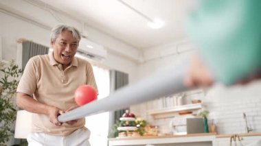 Yaşlı bir adam evde partneriyle top yuvarlama oyunu oynuyor, zihinsel ve fiziksel sağIık için el-göz koordinasyonu, odaklanma ve motor becerileri pratiği yapıyor. Sağlık hizmetleri konseptini engelliyor. Myrmidon.