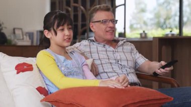 Büyükbaba ve torun birlikte TV 'de ilginç bir eğlence medyası izliyorlar. Eski üst düzey kullanım teknolojisi, genç nesil çapraz nesil ile iletişim kurarak aile bağlarını güçlendiriyor. Uyumsuzluk.