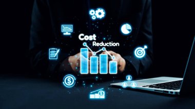 Bir iş adamı dijital simgeler ve grafiklerle maliyet azaltma stratejileri sunar. Modern çalışma alanı etkili mali yönetim için yenilikçi araçlar sergiliyor. Dörtgen