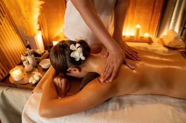 Beyaz kadın müşteri stres önleyici spa masajının keyfini çıkarıyor ve lüks otel ya da otelde sıcak mum ışığında güzellik teniyle eğleniyor. Sessiz.
