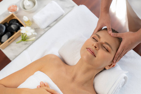 Panorama top view of woman enjoying relaxing anti-stress head massage and pampering facial beauty skin recreation leisure in dayspa modern light ambient at luxury resort or hotel spa salon. Quiescent