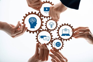 İşbirlikçi eller yapay zekayı, yeniliği ve multimedya kavramlarını sembolize eden vitesleri tutarlar. Görüntüler, dijital bir ortamda takım çalışmasını ve yaratıcı çözümleri temsil ediyor. Dostluk