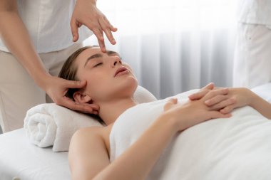 Kafkasyalı kadın stres önleyici kafa masajından ve lüks tatil beldesi ya da otel spa salonundaki modern ışık ortamında yüz güzelliği eğlencelerini şımartmaktan hoşlanıyor. Sessiz.