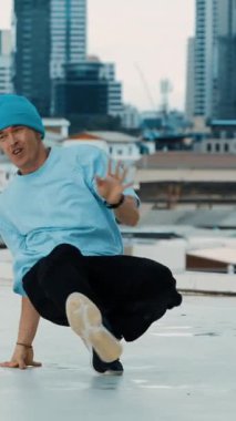 Profesyonel beyaz dansçı, şehir ya da şehirle çatıda sokak dansı yapıyor. Genç adamın sokak dansı yaparken dondurucu poz vermesi. Açık hava sporu 2024 hiphop..