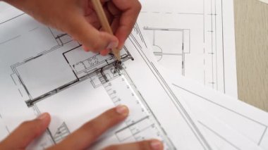 Ölçüm aracı ve kalem el kullanan akıllı mimar veya akıllı mühendisin videosu mimari ofisteki inşaat hatasızlığı için ayrıntılı bir tasarım hazırladı. Eline odaklan. - Yakın çekim. Tanımlama.