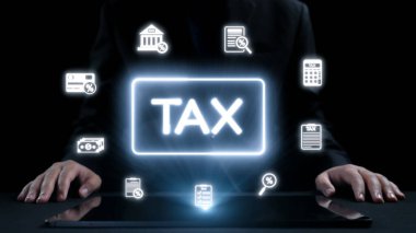 Bir işadamı, vergilendirme ve uyum karmaşıklığını gösteren çeşitli mali simgelerle çevrili dijital bir ekranda vergiyle ilgili bilgileri analiz eder. Dörtgen