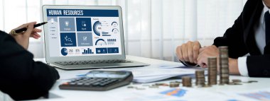 İnsan kaynakları yönetim yazılımı bilgisayar ekranında insan kaynakları çalışanlarının işe alım, maaş bordrosu, personel araması ve KPI değerlendirme çalışmalarını yönetmesine yardımcı oluyor