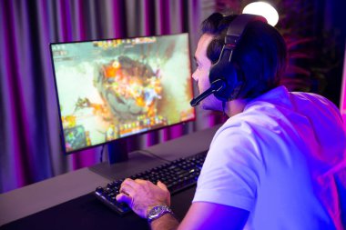 Moba çevrimiçi oyununa odaklanan akıllı akım oyunculu kulaklıklar takarak bilgisayar ekranında mupti ya da neon dijital siber ışık odasındaki savaş alanında yetenekli bir takım ile birlikte. Tahmin et..