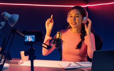 Yaratıcı yayın kanalı sosyal medyada pozitif podcasttaki dinleyicilerle birlikte müziği dinliyor, pastel renkli kulaklıklar takıyor, neon stüdyodaki kameraların mikrofon kayıtlarını kullanıyor. Taktik.