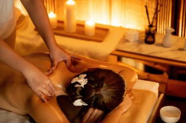Beyaz kadın müşteri stres önleyici spa masajının keyfini çıkarıyor ve lüks otel ya da otelde sıcak mum ışığında güzellik teniyle eğleniyor. Sessiz.