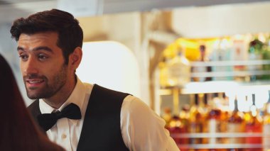 Gülümseyen zeki barmen, gece kulübünde VIP müşterilerle canlı sohbetler yapmak için güzel bir gece partisi atmosferine mükemmel bir servis sunuyor. Vinosity.